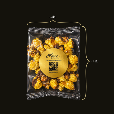 Packaged chocolate banana popcorn with a gold label and dimensions indicated on a black background