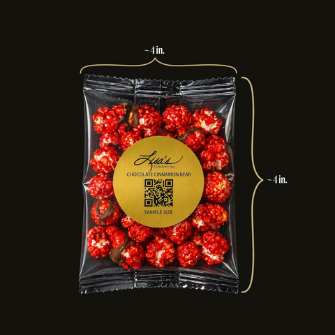 Packaged red chocolate cinnamon bear popcorn with a gold label on a black background