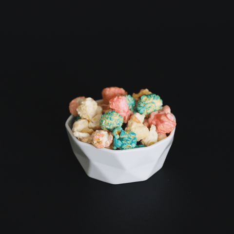 Berries and cream popcorn, Pink, white and blue popcorn in white bowl with black background - lisa's popcorn